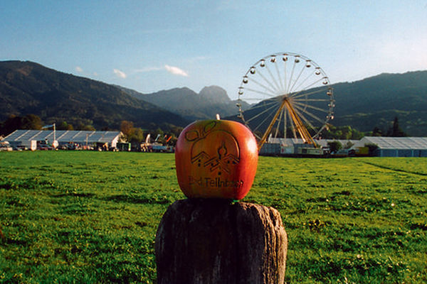Blick auf das Gelände des Feilnbacher Apfelmarktes mit Riesenrad und traumhafter Bergkulisse im Hintergrund.