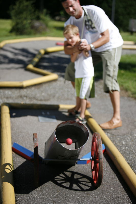 Vater mit Sohn beim Minigolf