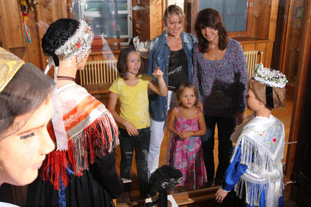 Besucher im Schwarzwälder Trachtenmuseum vor der Vitrine mit der Kinzigtäler Tracht