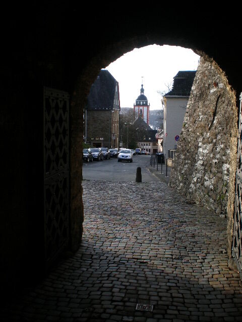 Blick durch den Torbogen des Oberen Schlosses auf die Burgstrasse. Im Hintergrund ist die Nikolaikirche zu sehen.