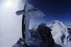 Auf dem felsigen Gipfel des Nadelhorns steht ein Gipfelkreuz.